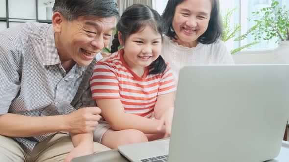 grand mother grandfather teach little child son granddaughter using laptop