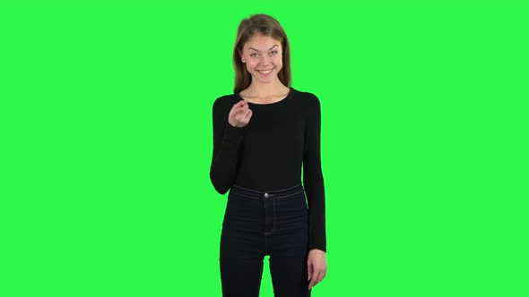 Young Woman Listens Carefully, Threatens with a Finger and Waves Her Head Seductively. Green Screen