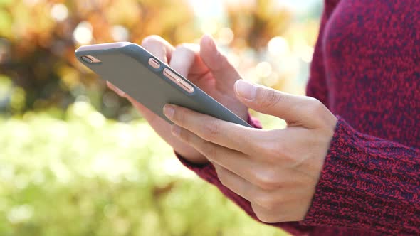 Woman using cellphone with autumn scene 