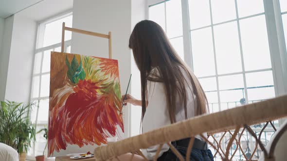 Woman at Work Upon Impressive Picture of Colorful Flowers