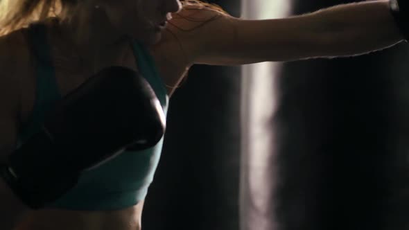 Woman does Muay Thai kickboxing training at the gym.