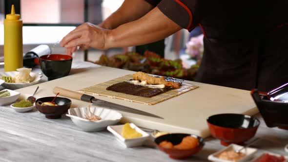 Male Hands Making Sushi Rolls.