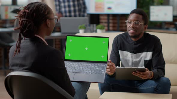 Female Employee with Greenscreen on Laptop Interviewing Man