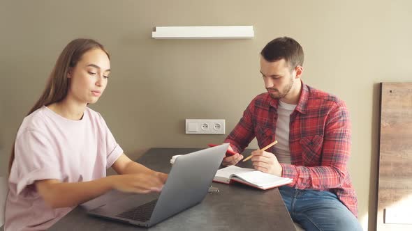 Handsome Man Together with Beautiful Young Woman Spending Time in Front of Laptop Computer