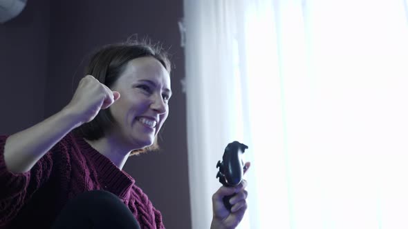 Joyful woman playing video games in front of TV