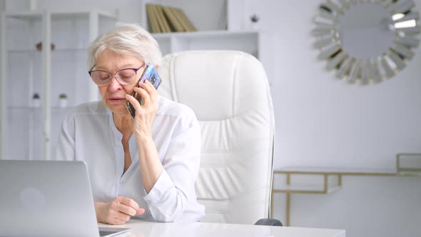 Concentrated old businesswoman with glasses