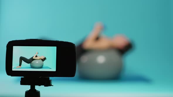 Fit Woman Doing Physical Exercise with Dumbbells on Video Camera