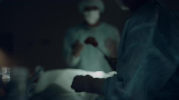 Nurse Handling Sterile Instruments Dark Room Closeup