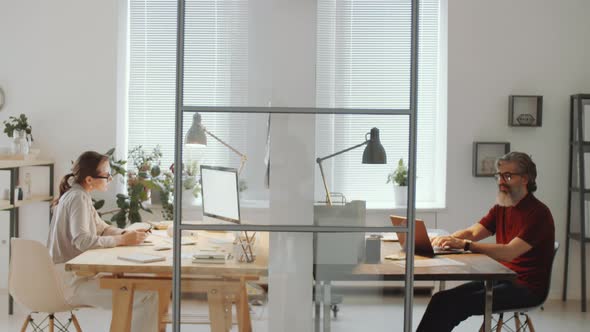 Businessman and Businesswoman Working in Modern Office