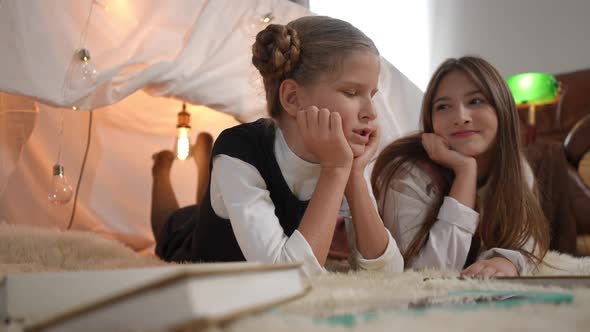 Positive Pretty Relaxed Girls Talking Gossiping Lying at Tent Indoors