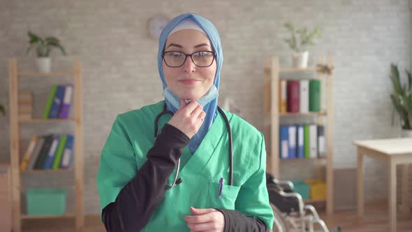 Portrait of Muslim Woman in Hijab Doctor Removes Bandage Smiling and Looking at Camera