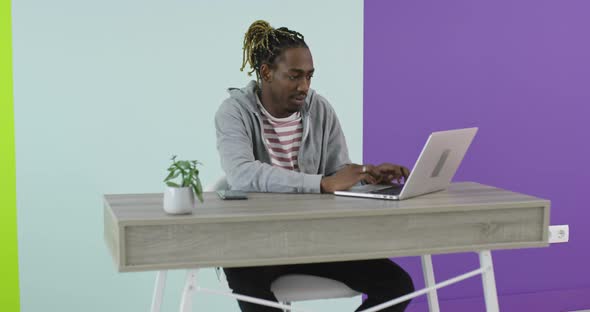 African Businessman Working on Laptop Sitting at Home Office Desk