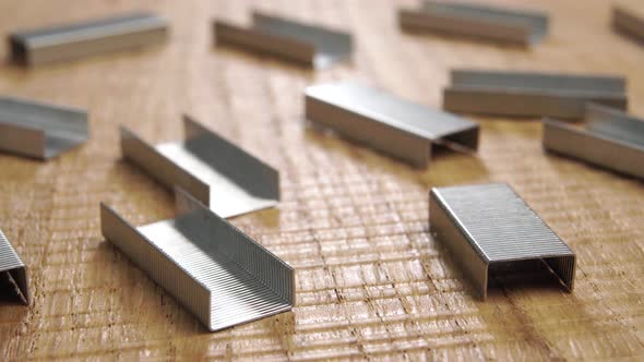 Stapler staples on a detailed wooden surface