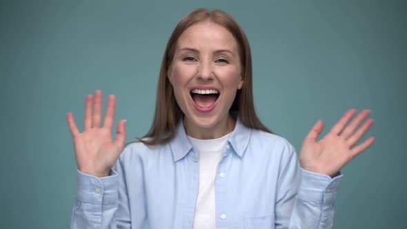 Hello, welcome. Portrait of happy young woman raising palm to wave hi