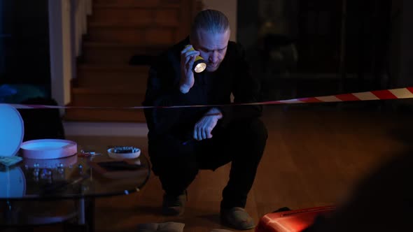 Front View Portrait of Focused Policeman with Flashlight Investigating Crime Indoors