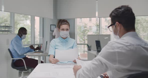 Female Employer Wearing Face Mask Holding Cv Listening Male Candidate at Job Interview