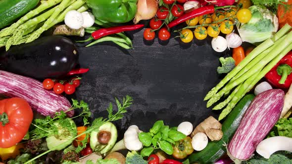 Huge Selection of Fresh Organic Vegetables on a Black Stone Background in the Centre.