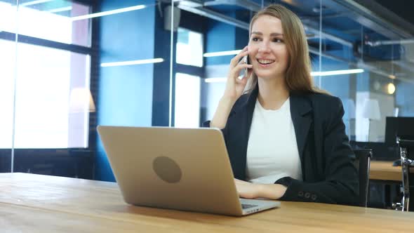 Woman Talking on Phone at Work