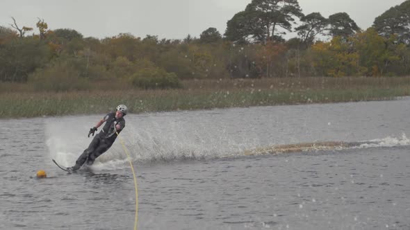 Young slalom water-skier cuts tight around buoy