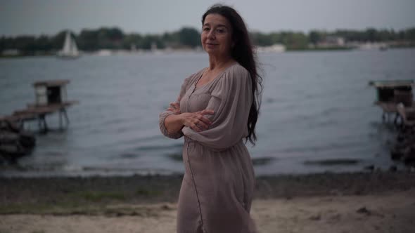 Side View Portrait Confident Senior Caucasian Woman Standing on Windy Day at Lake Shore Turning