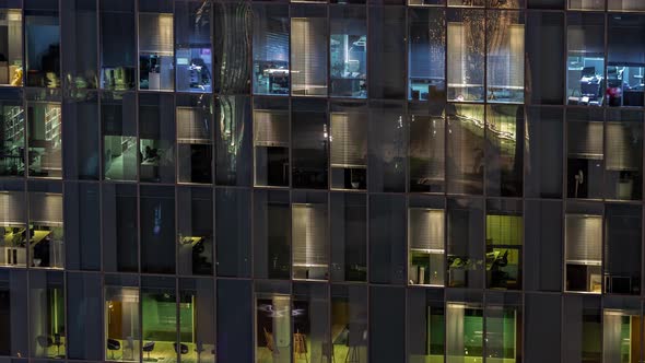 Night Aerial View of Office Building Glass Window Facade with Illuminated Lighted Workspace Rooms