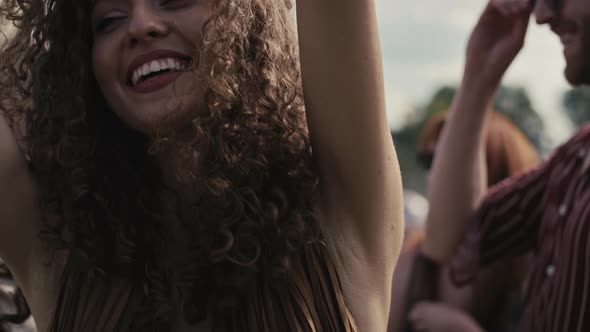 Close up of caucasian woman with curly hair dancing on music festival. Shot with RED helium camera i