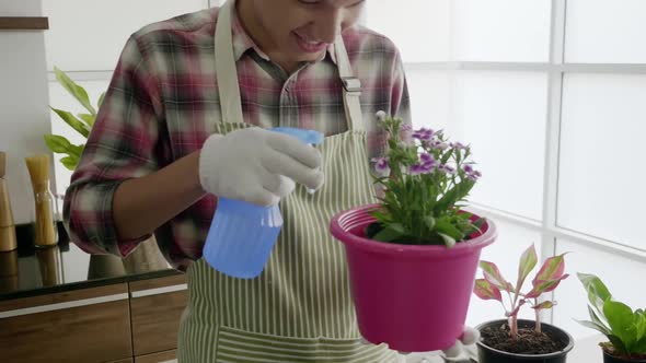 Asian man enjoys planting trees while relaxing at home.