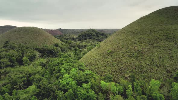 Filipino Closeup Aerial View of Chocolate Hills at Cloudy Sky Backdrop