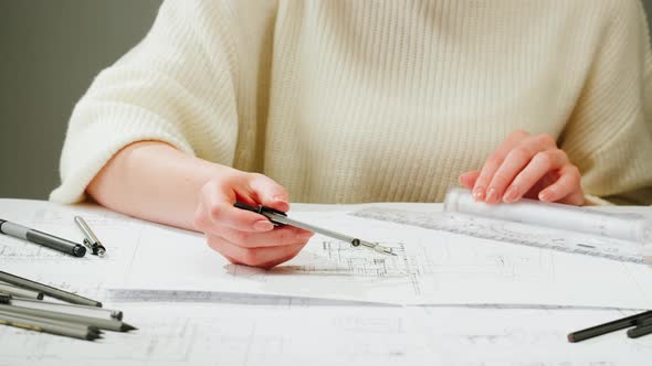 Architect Designer Using Compass to Draw Plan Blueprint Closeup