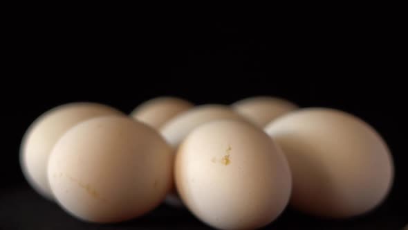 White Chicken Eggs Spinning on a Black Background Close Up
