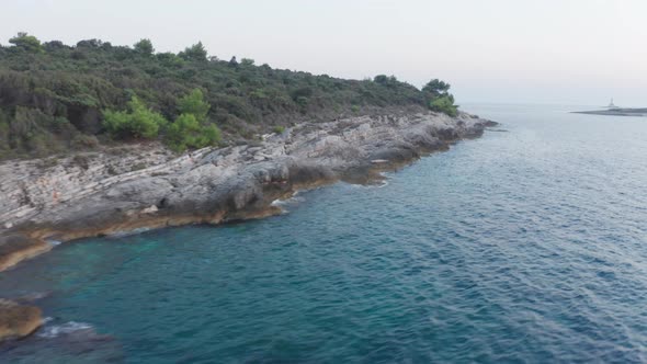 Aerial wide shot of the southern tip of Cape Kamenjak, Croatia. Lighthouse and small island in the b