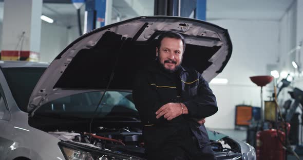 Attractive Mature Man Mechanic in a Modern Auto