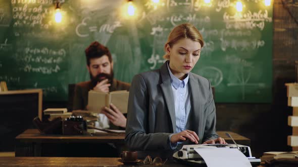 Professor and Secretary or Assistant Working at His Desk with Vintage Typewriter Front of a