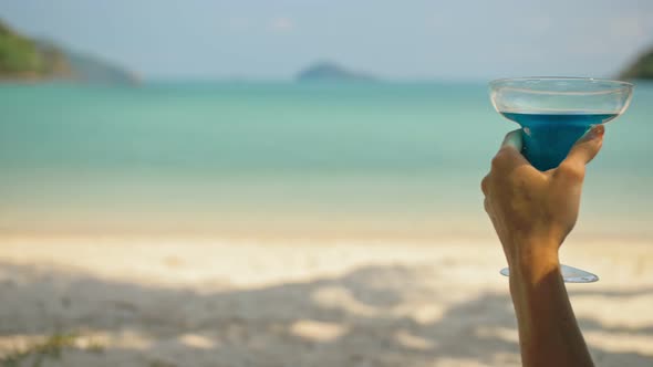 Woman Hands Shake Blue Cocktails in Glasses on Beach