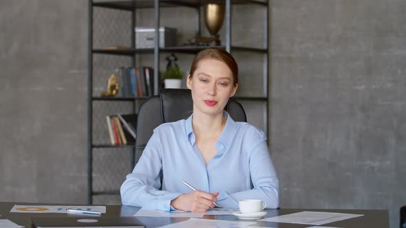 Young woman in suit communicating by video call