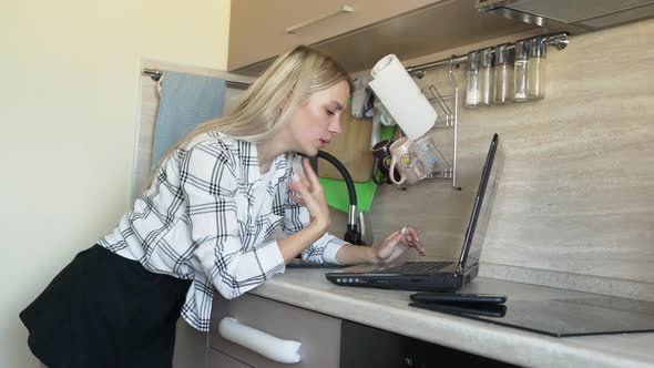 Woman Works Behind Laptop in Kitchen