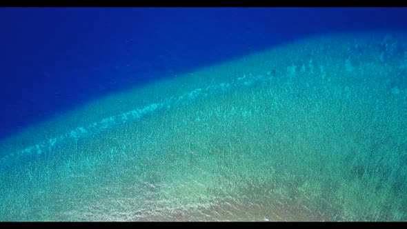 Aerial top down texture of idyllic coastline beach journey by blue green water with white sandy back