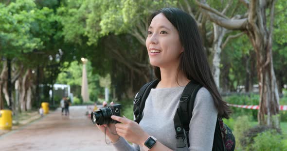 Young Woman taking photo on camera in the park