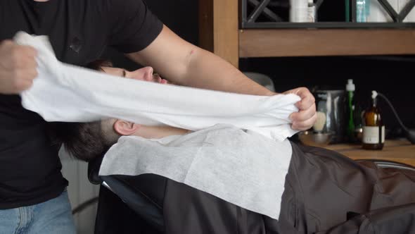 Barber Covering Face of Client with Towel