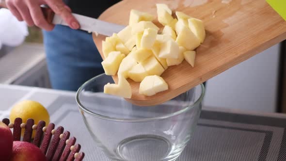 Apple Pie Preparation Series  Woman Pours Chopped Apples Into a Glass Bowl