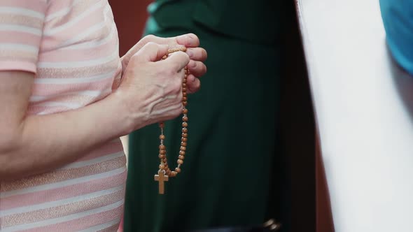 In Old Elderly Wrinkled Hands Woman Holds Catholic Rosary and Sorted Them Out