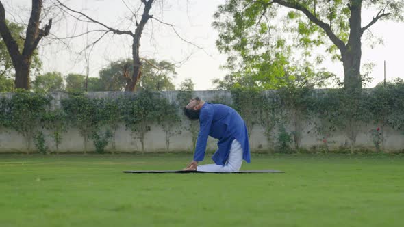 Camel Yoga pose or Ustrasana is being done by an Indian man