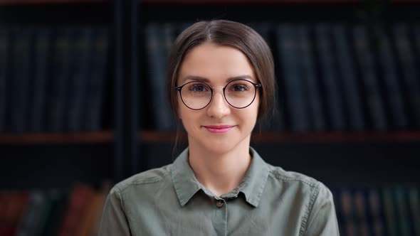 Cute Librarian Woman in Eyeglasses Smiling Posing at Bookshelves Bookcase Bookstore Library Closeup