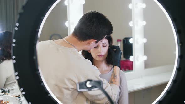 Brow Master Works with an Eyebrows of Attractive Woman Model in Backstage Room