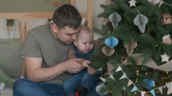 Dad Showing Decorated Christmas Tree to His Baby