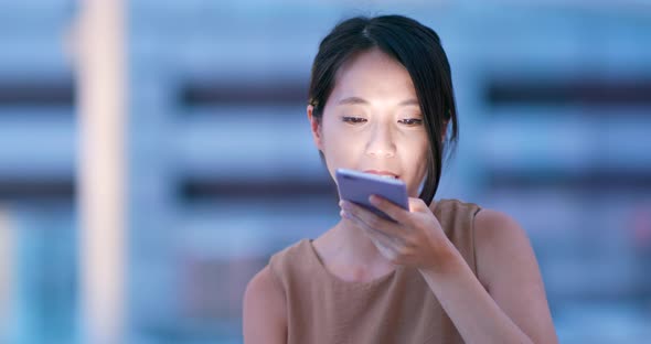 Woman use of mobile phone in city of Hong Kong at night