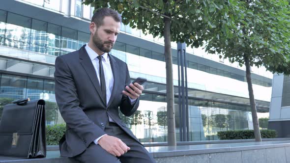 Businessman Using Smartphone for Reading Email