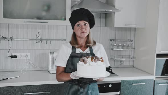 Woman Chef Holding a Finished Handmade Cake