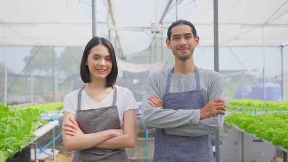 Asian couple farmers owner working in vegetables hydroponic farm with happiness and look at camera.