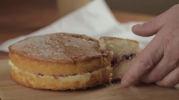 Slicing and serving Victoria sponge cake close up shot